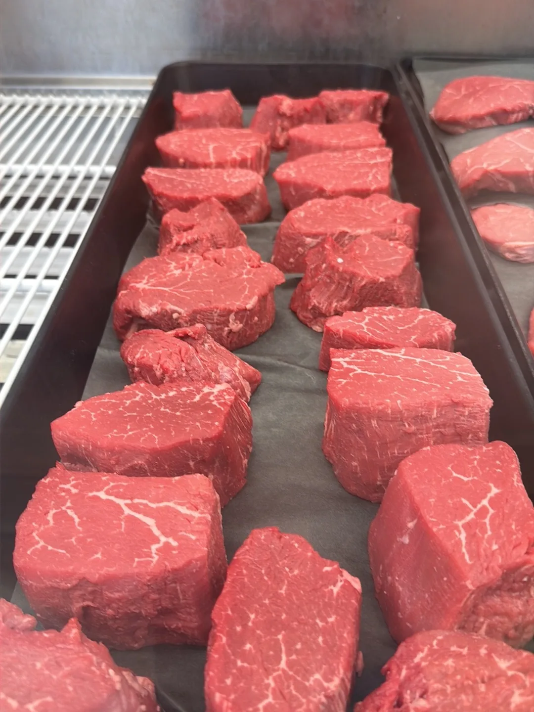 Tenderloin filets cut to thickness and lined up on a tray