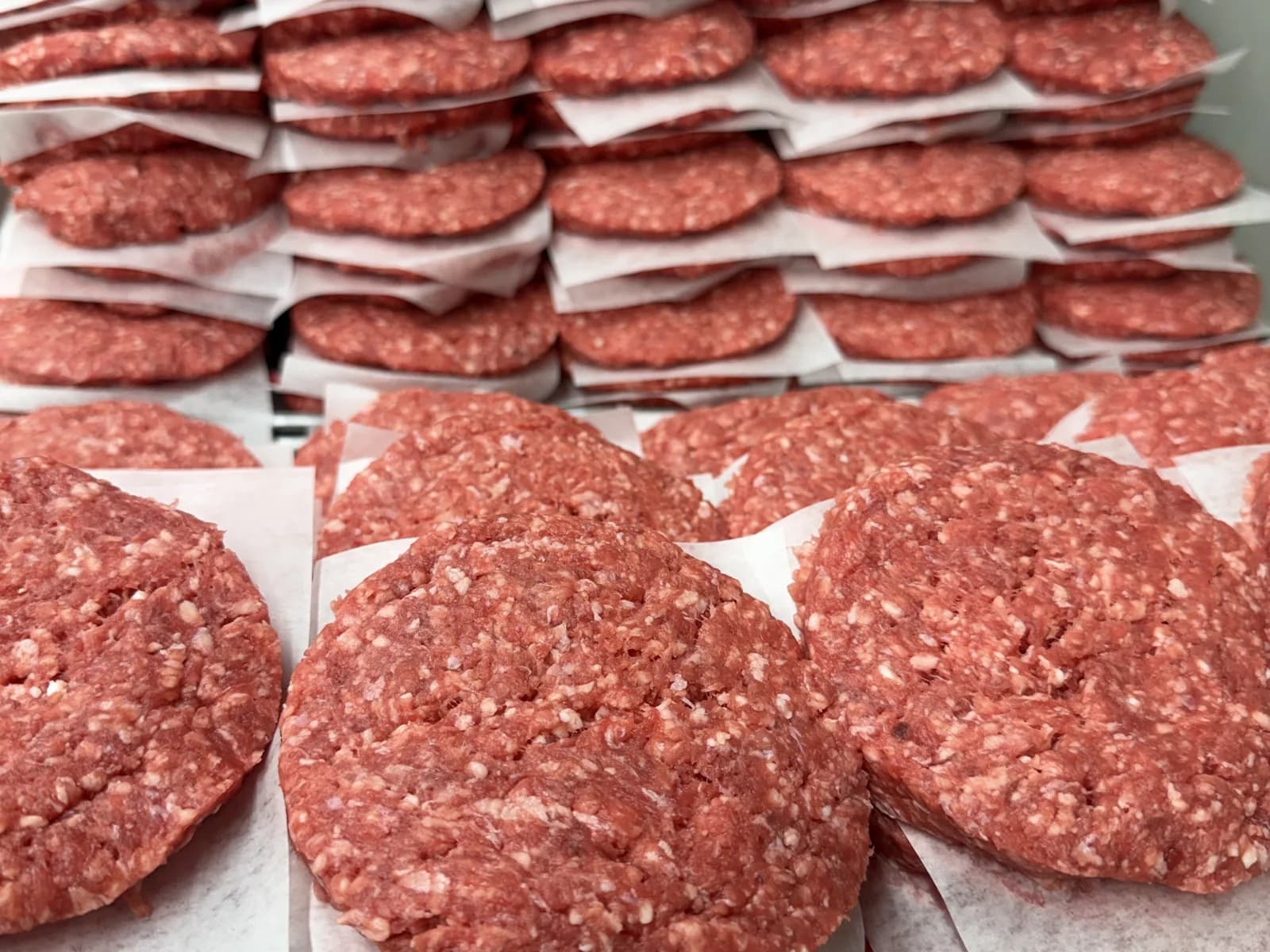 Close-up of stacked ground beef patties ready for packaging
