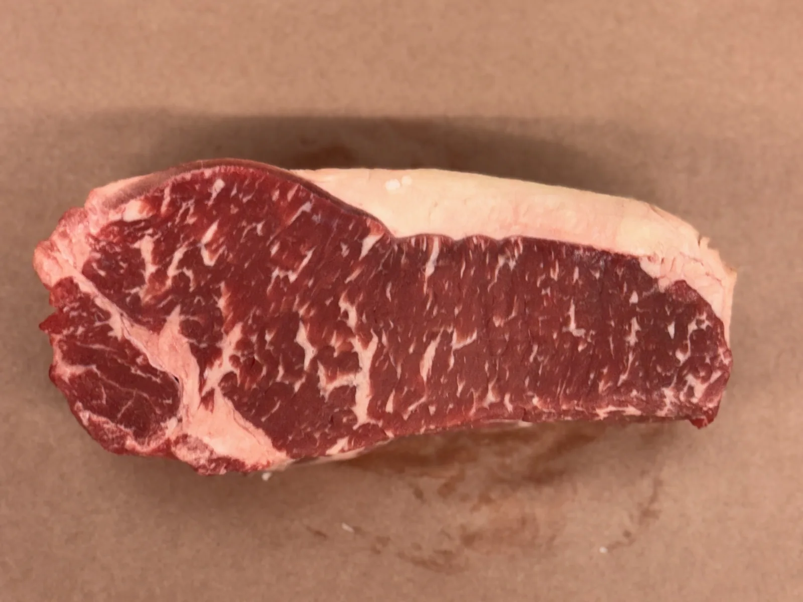 A New York strip steak on butcher paper